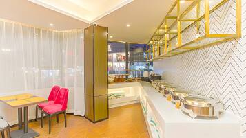 A modern kitchen with a buffet setup, a dining area with a table and chairs, and a herringbone patterned floor.