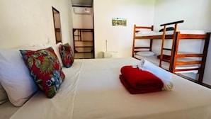 A hotel room with a bed, a bunk bed, a mirror, a shelf unit, and a small picture on the wall. - Pousada Aquarela Caraiva (Porto Seguro)