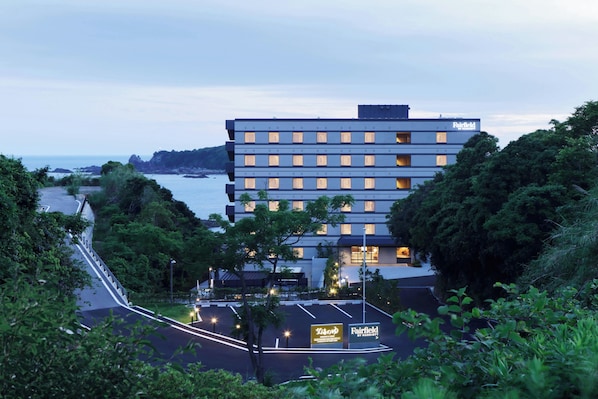 Et moderne hotel i flere etager, beliggende ved vandet med udsigt over kystlinjen.