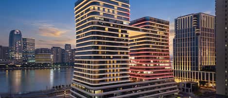 Ein Hochhaus-Hotel mit mehreren Etagen, Blick auf das Wasser und einem modernen architektonischen Design.