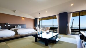 Ein Hotelzimmer mit Bett, einem kleinen Tisch und Blick aufs Meer.