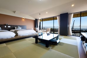 Habitació d'hotel amb un llit, una taula petita i vista al mar.