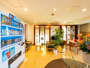 A hotel lobby with a vending machine, seating area, and a reception desk. - Beppu Onsen Choubounoyado Shiori (Beppu)