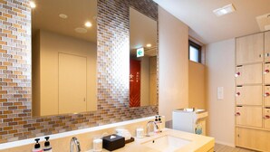 A hotel bathroom with two sinks, a large mirror, and a locker area. - Super Hotel Tokyo Shiba (Tokyo)