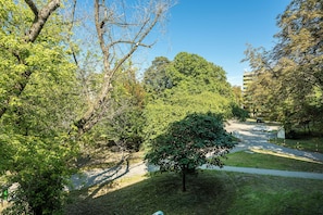 Un parque con un sendero pavimentado, árboles y un edificio al fondo.