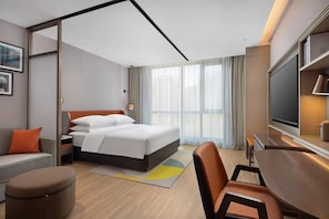 A hotel room with a bed, a desk, a TV, and a window with curtains. - Home2 Suites BY Hilton Xingwen Yibin (Yibin)