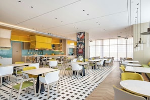 A modern restaurant with a central bar area, multiple dining tables, and chairs. - Home2 Suites BY Hilton Xingwen Yibin (Yibin)
