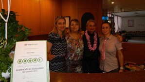 Un grupo de personas en el vestíbulo de un hotel, con una mesa de recepción y un certificado en el mostrador.