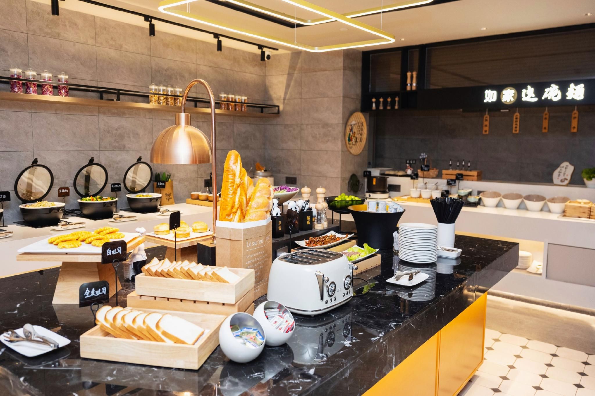 A buffet setup with various food items and a toaster.