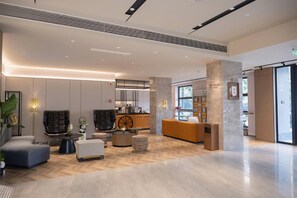 A modern lobby with a reception desk, seating area, and a large window providing natural light. - Homeinn Plus (Chengdu)