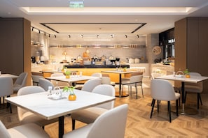 A modern restaurant interior with a bar area, seating arrangements, and a visible kitchen. - Homeinn Plus (Chengdu)