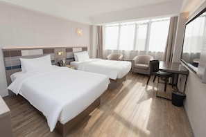 A hotel room with two beds, a desk, a chair, a TV, and a window with curtains. - Homeinn Plus (Chengdu)
