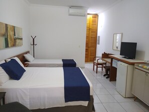 A hotel room with two beds, a desk, a television, and a wardrobe. - Riviera Service- Hotel Suites 209 e 308 (Bertioga)