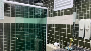 Un bagno con doccia vetro, un water e un lavabo con piano in marmo.
