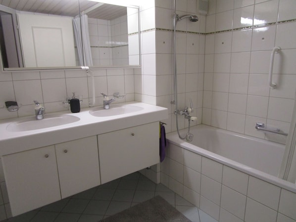Un bagno con due lavandini, uno specchio, una doccia e una vasca da bagno.