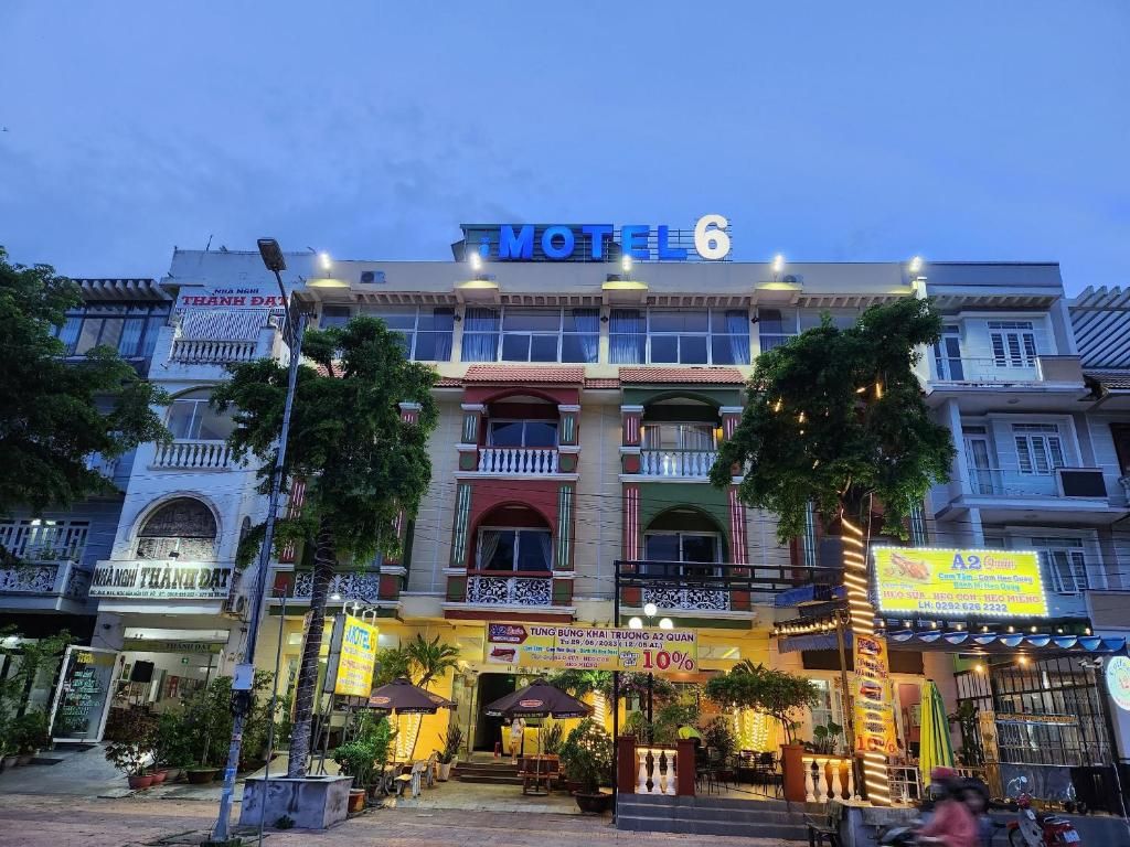 Un edificio de varios pisos con un llamativo letrero de 'Motel 6'.