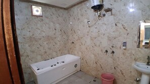 Casa de banho com banheira branca, pia e chuveiro.