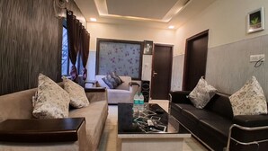 Una sala de estar con dos sofás, una mesa de centro y un televisor.