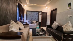Ein Wohnzimmer mit zwei Sofas, einem Couchtisch und einem Fernseher.