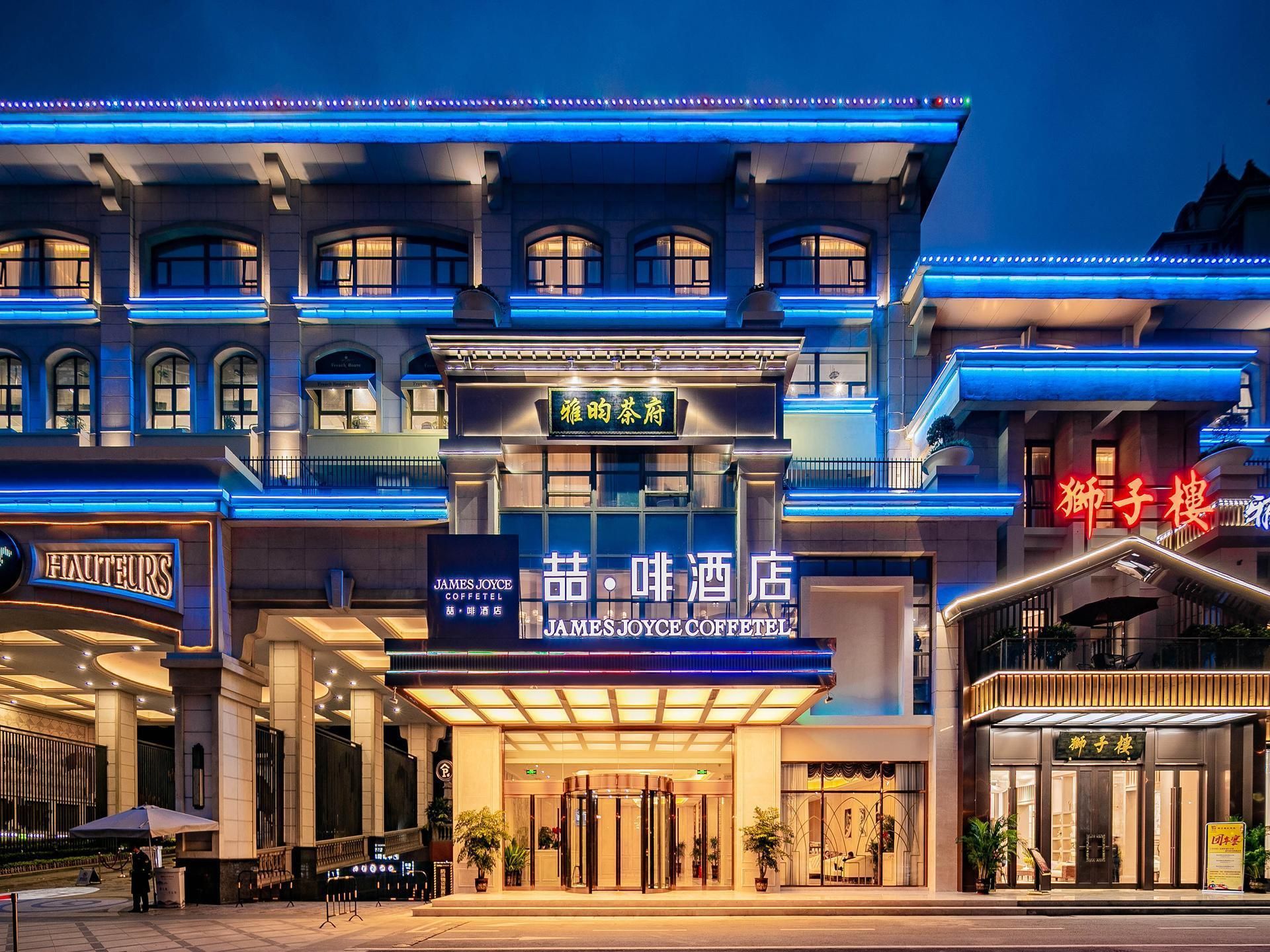A hotel facade with signage for James Joyce Coffee and a traditional Chinese restaurant.