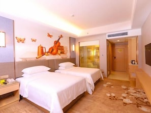 A hotel room with two beds, a desk, a chair, a TV, and a door leading to a bathroom. - Vienna International Hotel (Foshan)
