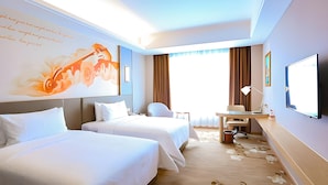 A hotel room with two beds, a desk, a chair, a television, and a large window with curtains. - Vienna International Hotel (Foshan)