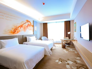 Ein Hotelzimmer mit zwei Betten, einem Schreibtisch, einem Stuhl, einem Fernseher und einem großen Fenster mit Vorhängen.