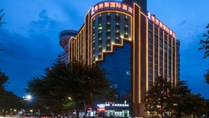 Een meerhoog hotel met verlichte borden en een modern architectonisch ontwerp.