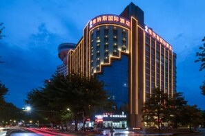 Un hotel de varios pisos con señalización iluminada y un diseño arquitectónico moderno.