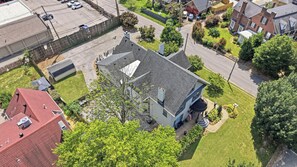 A residential area with a two-story house featuring a large front yard, a garage, and a driveway. - Cozy Phoenix Hill suite in the heart of Louisville (Louisville)