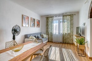A living room with a wooden dining table, a sofa, a fan, and a television. - A spacious apartment of approximately 100 sqm, accommodating up to 7 people and laid out over two floors (with internal stairs leading to the upper level).The property is located in Tordandrea, a quiet hamlet of Assisi, in an area with good local ameniti (Tordandrea)