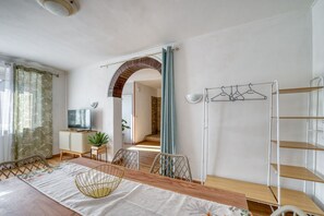 A dining area with a wooden table, chairs, a hanging light fixture, and a television on a cabinet. - A spacious apartment of approximately 100 sqm, accommodating up to 7 people and laid out over two floors (with internal stairs leading to the upper level).The property is located in Tordandrea, a quiet hamlet of Assisi, in an area with good local ameniti (Tordandrea)