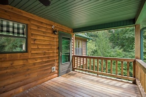 Eine Holzhütte mit Veranda, einer Tür und einem Fenster.