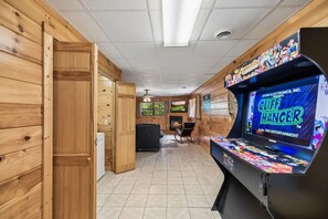 Ein Zimmer mit Holzwänden, einem Kamin, einem Fernseher und einer Krallenmaschine.
