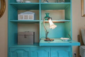 A teal-colored cabinet with a desk lamp, a small box, and a drawer. - Spacious 3BR Crescent Hill Apt | Yard & Parking (Louisville)