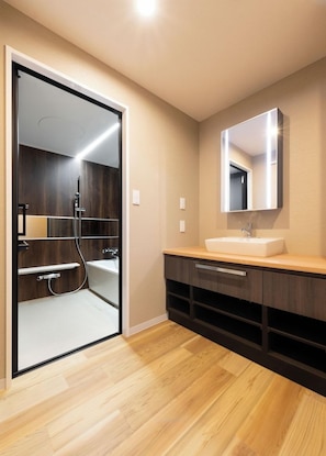 A modern bathroom with a glass shower enclosure, a white sink, and a wooden vanity. - Hotel Legit Hiroshima (Hiroshima)