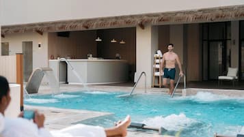 Zona de piscina con bar y sillones de descanso.
