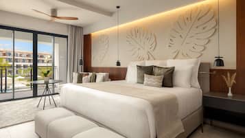A modern bedroom with a large bed, a ceiling fan, a view of the outside, and a nightstand with a lamp.
