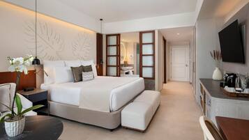 A modern hotel room with a large bed, bedside tables, a desk, and a TV.