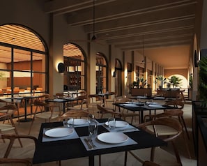 Un restaurant amb taules preparades per dinar, amb un interior modern, caires de fusta i teles de taula negres.