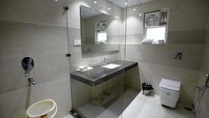 Un baño moderno con ducha de vidrio, lavamanos e inodoro.