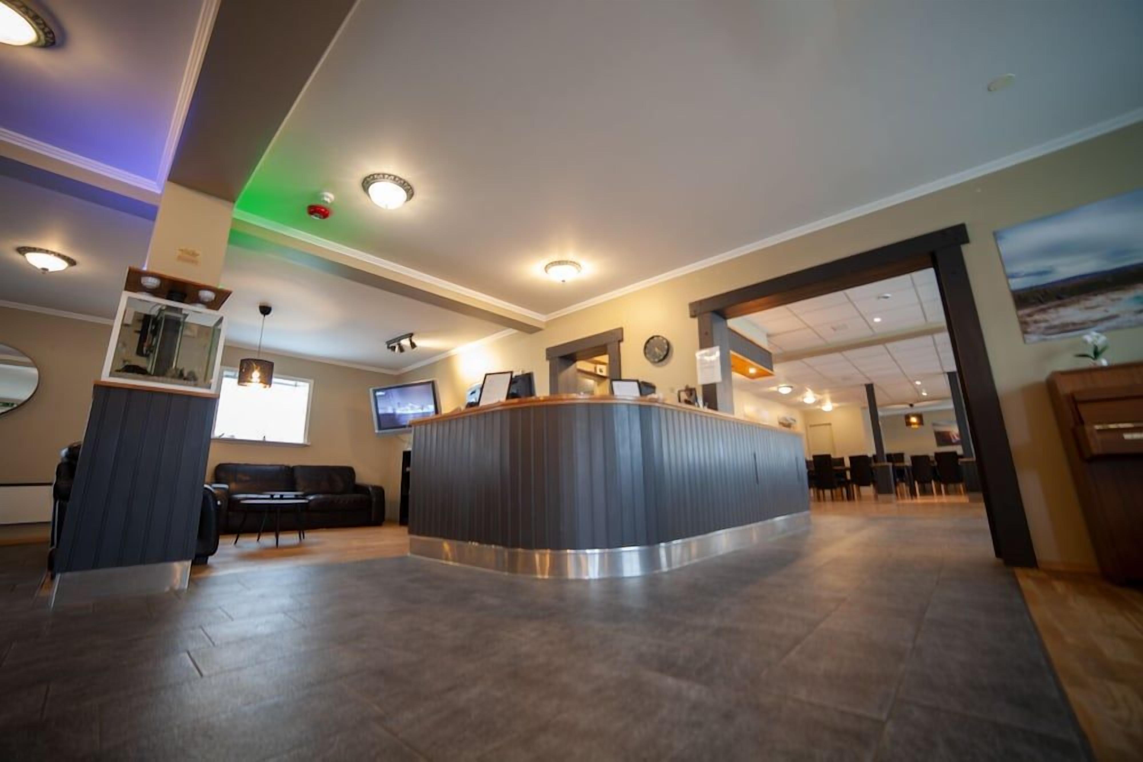 A reception area with a curved counter, seating area, and a television.