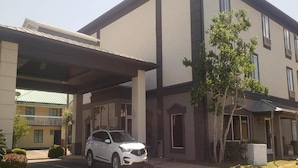 A two-story building with a covered entrance and a parked car. - Motel6 Mobile, AL Airport Blvd (Mobile)