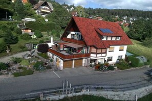 A two-story house with a red roof, a balcony, and a garage. - Holiday apartment with 2 bedrooms (Sasbachwalden)