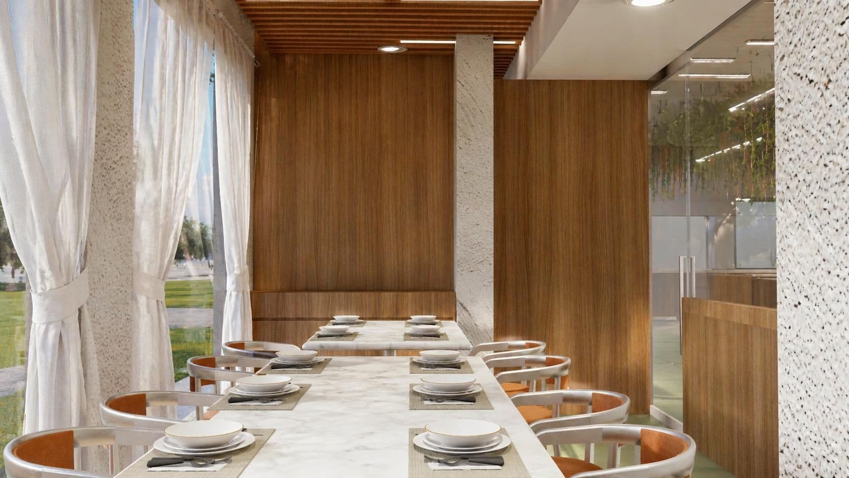 Un comedor moderno con una mesa larga dispuesta para varios comensales, paneles de madera en las paredes y vistas al exterior.