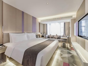 Quarto de hotel moderno com uma cama grande, uma escrivaninha e uma janela com vista.