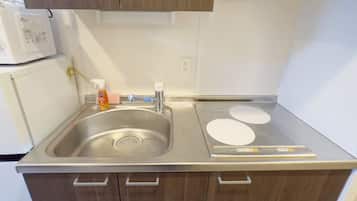 A kitchen with a stainless steel sink, a built-in microwave, and a stove with a digital control panel.
