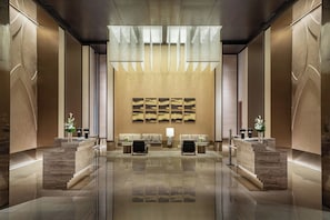 A modern lobby with a reception desk, seating area, and artwork on the wall. - Intercontinental Wuxi Taihu New City (Wuxi)