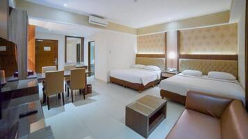 A hotel room with two beds, a sitting area, and a dining area.