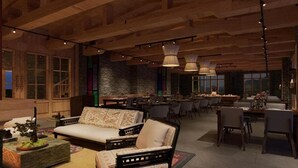 A spacious living area with a sofa, dining tables, and hanging lights. - Taj Gangtey Resort & Spa, Bhutan (Wangdue Phodrang)